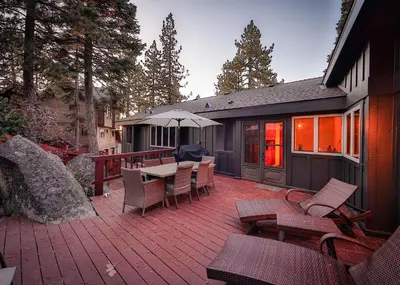 a patio with a table and chairs and an umbrella at Sunset Cove Chic Tahoe Retreat in Glenbrook