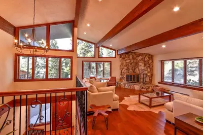 a large living room with a stone wall at Sunset Cove Chic Tahoe Retreat in Glenbrook