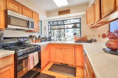a kitchen with wooden cabinets and a stove and a window at Tahoe Family Getaway in Stateline