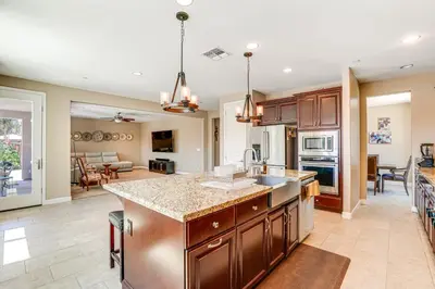 a kitchen with wooden cabinets and a kitchen island in a room at 4 Mi to The Streets of Brentwood Home with Fire Pit in Brentwood