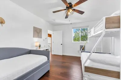 a bedroom with a couch and bunk beds and a ceiling fan at Family Retreat Mountain View with Hot Tub and Mini Golf in Steamboat