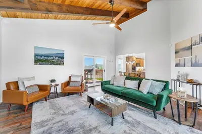 a living room with a green couch and chairs at Family Retreat Mountain View with Hot Tub and Mini Golf in Steamboat