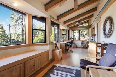 a living room with windows and a table and chairs at Mountainside Overlook Lake Views & Hot Tub in Kings Beach