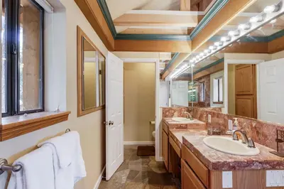a bathroom with two sinks and two mirrors at Mountainside Overlook Lake Views & Hot Tub in Kings Beach
