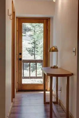 a door leading into a room with a table with a lamp at North Lake Hideaway Prime Locale for Outdoor Fun in Alpine Meadows