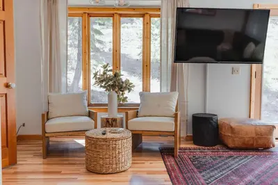a living room with two chairs and a flat screen tv at North Lake Hideaway Prime Locale for Outdoor Fun in Alpine Meadows