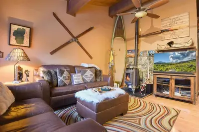 a living room with a leather couch and a fireplace at North Lake Tahoe Alpine Retreat 5 Min to Skiing in Alpine Meadows