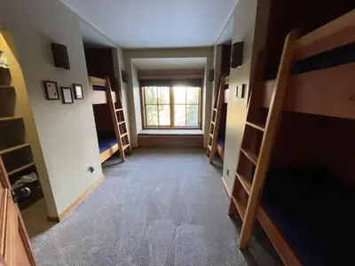 a room with several bunk beds and a window at Luxury Northstar Palace with Hot Tub & Games in Truckee