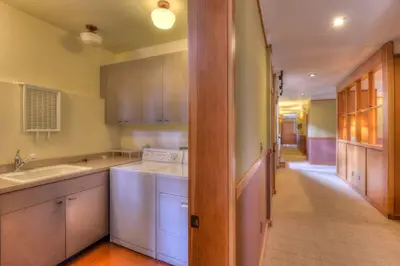 a kitchen with white cabinets and a sink and a hallway at Luxury Northstar Palace with Hot Tub & Games in Truckee
