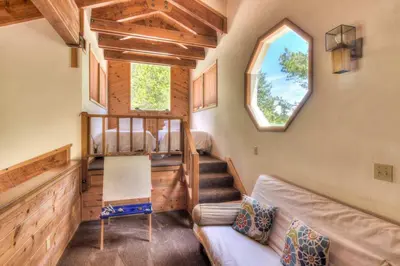 a living room with a couch and stairs in a tiny house at Northwoods Hangout Near Tahoe Donner in Truckee