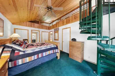 a bedroom with a bed and a spiral staircase at Paradise Pines 3BR Secluded Cabin Minutes in Tahoe Donner in Truckee