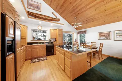 a large kitchen with wooden cabinets and a table at Paradise Pines 3BR Secluded Cabin Minutes in Tahoe Donner in Truckee