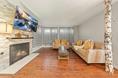 a living room with a couch and a fireplace at Powder Run Retreat Modern Stay for 6 With On-site Ski Access & Mountain Views in Truckee