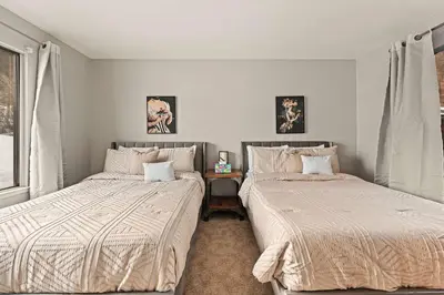 two beds sitting next to each other in a bedroom at Powder Run Retreat Modern Stay for 6 With On-site Ski Access & Mountain Views in Truckee