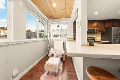 a dog sitting on a swing in a kitchen at Powder Run Retreat Modern Stay for 6 With On-site Ski Access & Mountain Views in Truckee