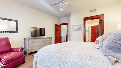 a bedroom with a bed and a tv and a chair at Timbers #2 townhouse in Mammoth Lakes