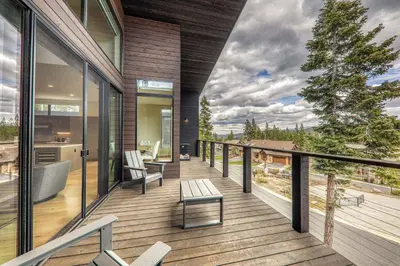 a balcony of a house with a tub and a tree at Village Walk 7470 by East West Hospitality in Truckee