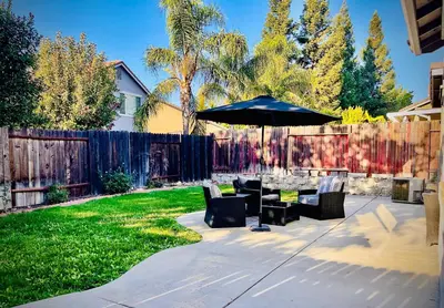 a patio with a table and an umbrella at Huge Home near Old Folsom Pet & Family Friendly in Folsom