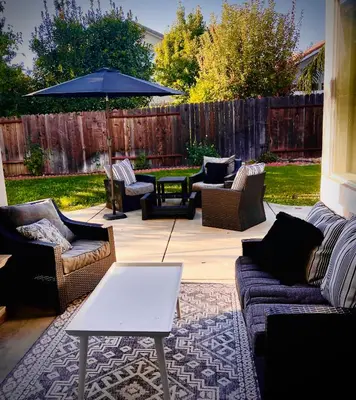 a patio with couches and a table and an umbrella at Huge Home near Old Folsom Pet & Family Friendly in Folsom