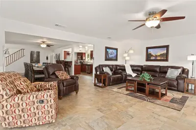 a living room with leather furniture and a ceiling fan at Rivertop Hideaway in Ahwahnee