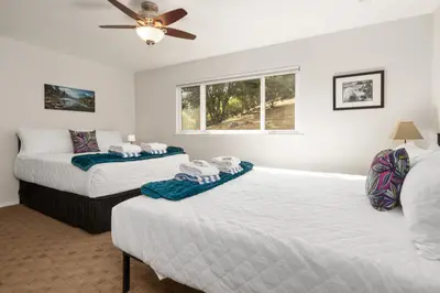 a bedroom with two beds and a ceiling fan at Rivertop Hideaway in Ahwahnee