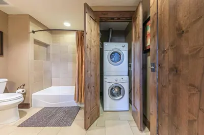 a bathroom with a washer and dryer next to a toilet at Northstar Lodge 306 by East West Hospitality in Truckee