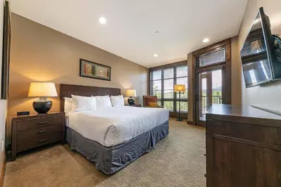 a bedroom with a bed and a desk with a television at Northstar Lodge 306 by East West Hospitality in Truckee