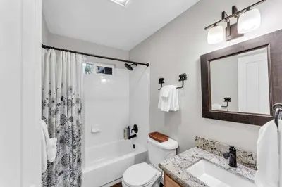 a bathroom with a sink and a toilet and a mirror at Tahoma Family Getaway with Bocce Ball & BBQ Grill in Tahoma