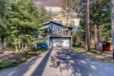 a house with a garage in the middle of a road at Tahoma Family Getaway with Bocce Ball & BBQ Grill in Tahoma