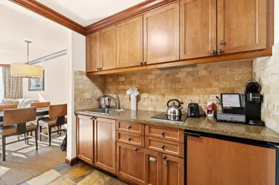 a kitchen with wooden cabinets and a counter top at Everline Resort & Spa Palisades-Valley View Suite in Olympic Valley