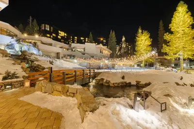 a resort in the snow at night with christmas lights at Everline Resort & Spa Palisades-Valley View Suite in Olympic Valley