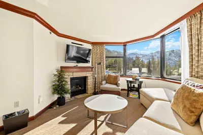 a living room with a fireplace and a tv at Everline Resort & Spa Palisades-Valley View Suite in Olympic Valley