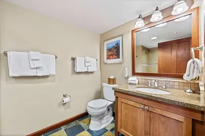 a bathroom with a toilet and a sink and a mirror at Everline Resort & Spa Palisades- Valley View in Olympic Valley