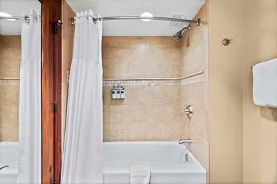 a bathroom with a white tub and a shower at Everline Resort & Spa Palisades- Valley View in Olympic Valley