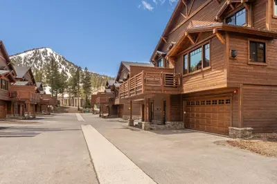 a large wooden house on a street with a mountain at Mountainside 14 in Mammoth Lakes