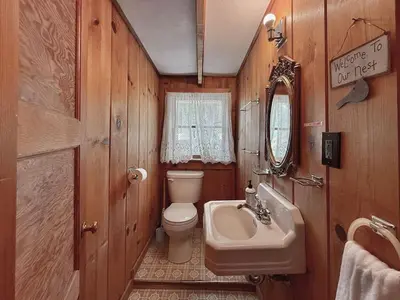 a bathroom with a toilet and a sink and a mirror at Homestead Ranch near Yosemite with Horses and Chickens in Midpines
