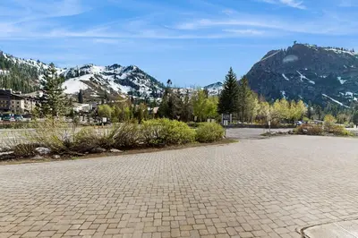 an empty parking lot with mountains in the background at Basecamp Bliss in Olympic Valley