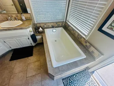 a bath tub in a bathroom with a sink at Pinkie's Suite -Hot Tub-BBQ-views in Ahwahnee