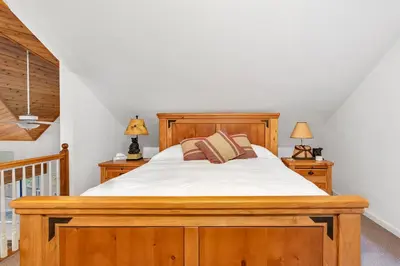 a bedroom with a wooden bed and two lamps at Fully Renovated 3Bd at Yosemite's South Gate in Fish Camp