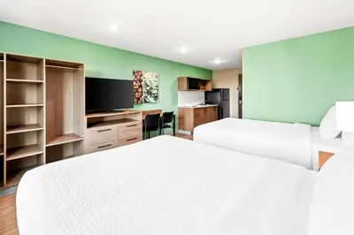 a hotel room with two beds and a flat screen tv at ECHO Suites Extended Stay by Wyndham Reno in Reno