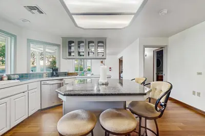 a kitchen with a large island with stools at Deer Paradise in Coarsegold