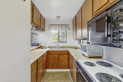 a kitchen with wooden cabinets and a white stove top oven at The Garden Haus in Incline Village