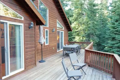 a deck with a grill and chairs on a cabin at Modern Retreat in Truckee with AC and Game Room in Truckee