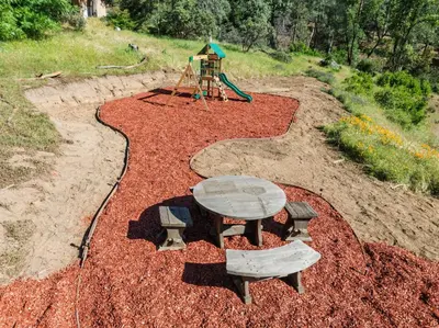 a playground with a picnic table and a play set at Yosemite Family Ranch in Oakhurst