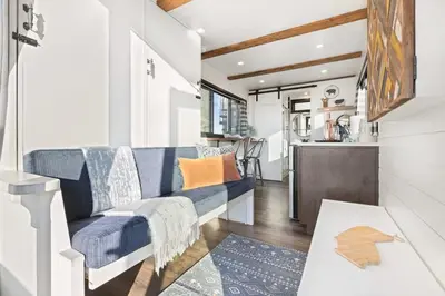 a living room with a couch and a table at Rooftop Spa Tiny Cargo Home Farm Experience in Tulare