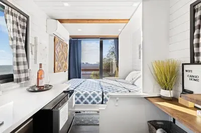 a bedroom with a bed and a window at Rooftop Spa Tiny Cargo Home Farm Experience in Tulare