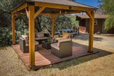 a wooden gazebo with chairs and a table at Bear Hollow by Sequoia National Park in Three Rivers