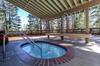 a hot tub on a patio with a bench at Hidden Valley #41 condo in Mammoth Lakes