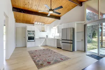 a kitchen with white cabinets and a ceiling fan at 4 Mi to Folsom Lake Modern Home with Patio! in Granite Bay