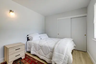 a white bedroom with a bed and a night stand at 4 Mi to Folsom Lake Modern Home with Patio! in Granite Bay